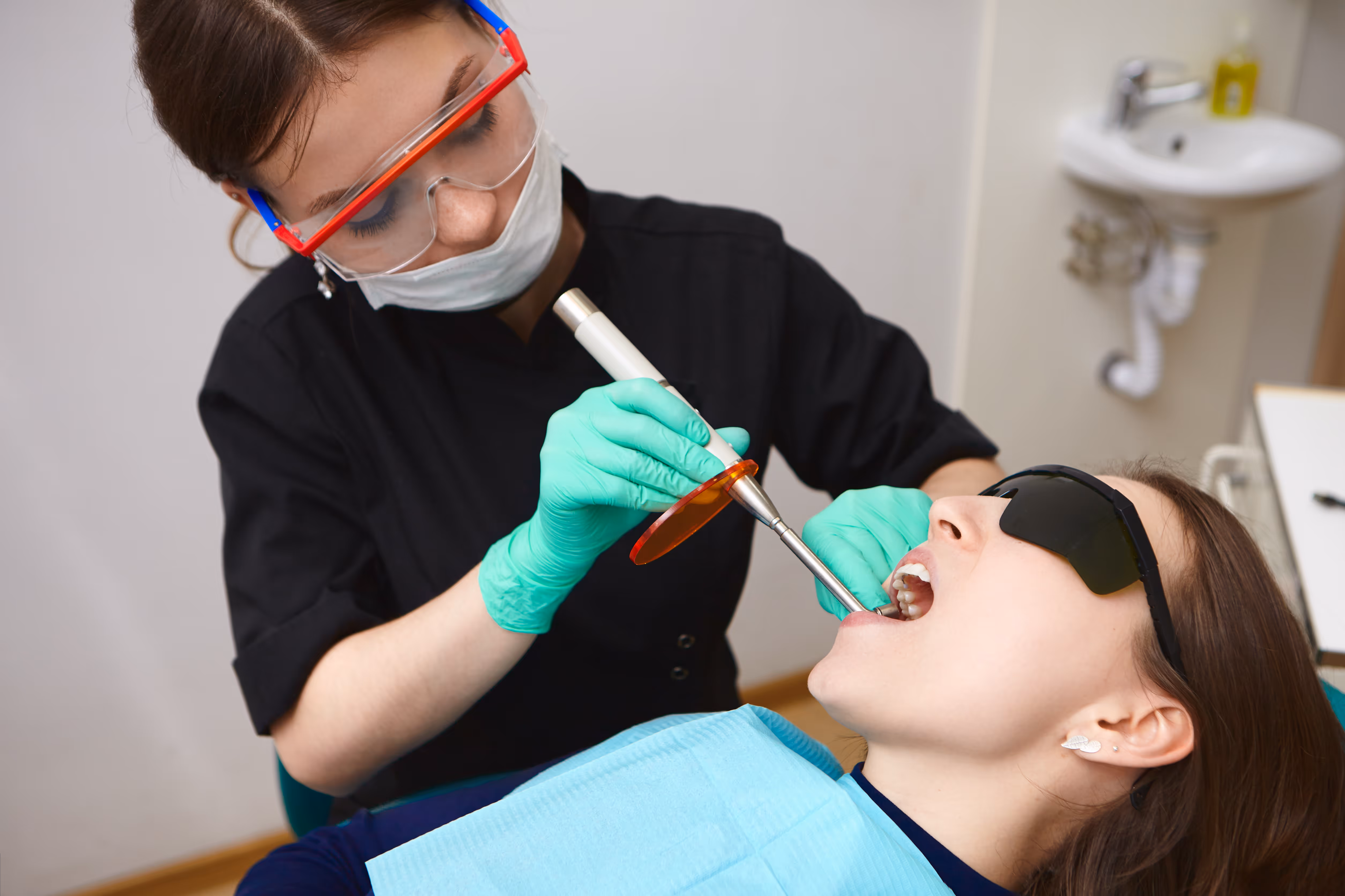 A dental hygienist treating a patient in a clinic in Canada