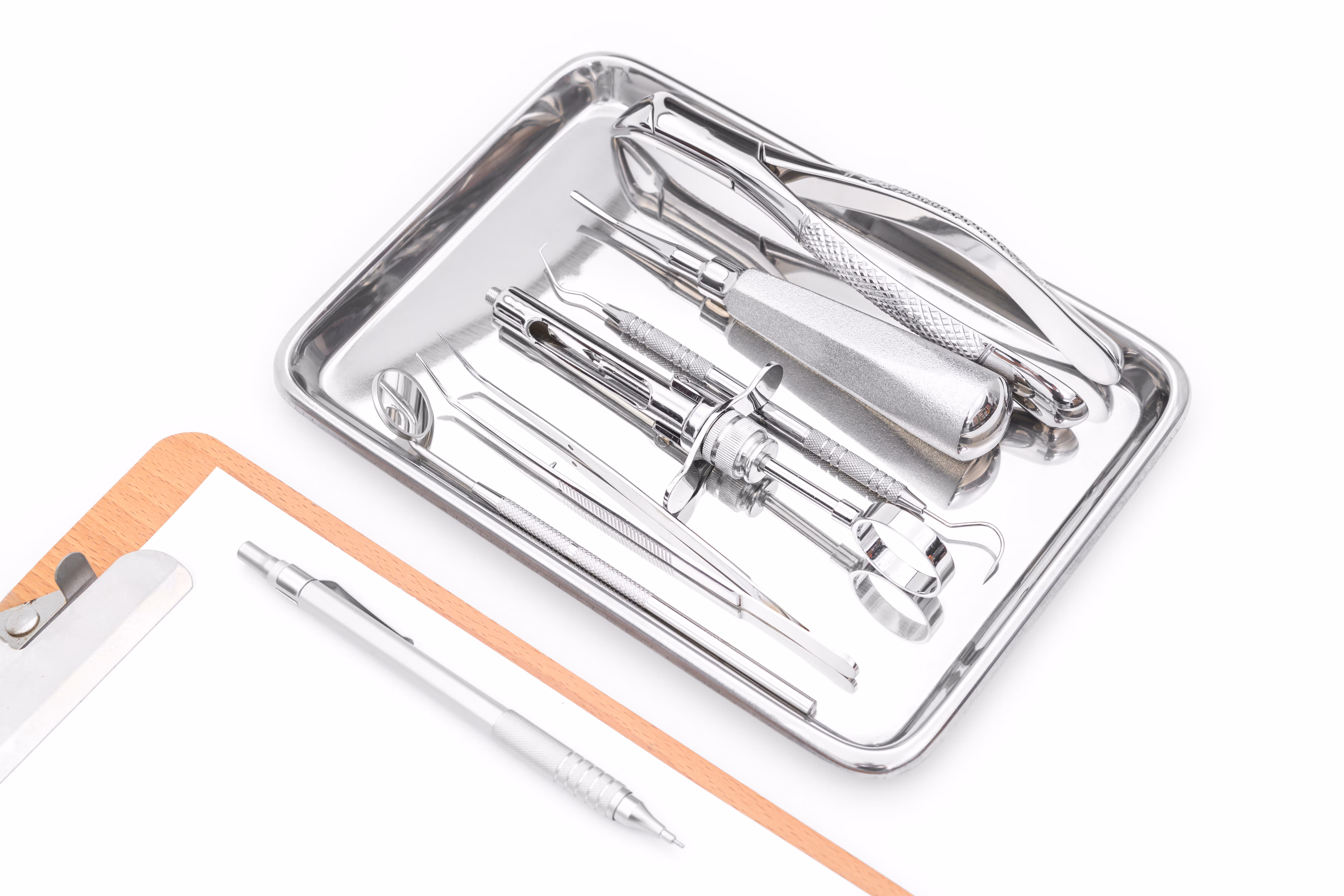 Dental instruments and a tooth chart laid out on a white background