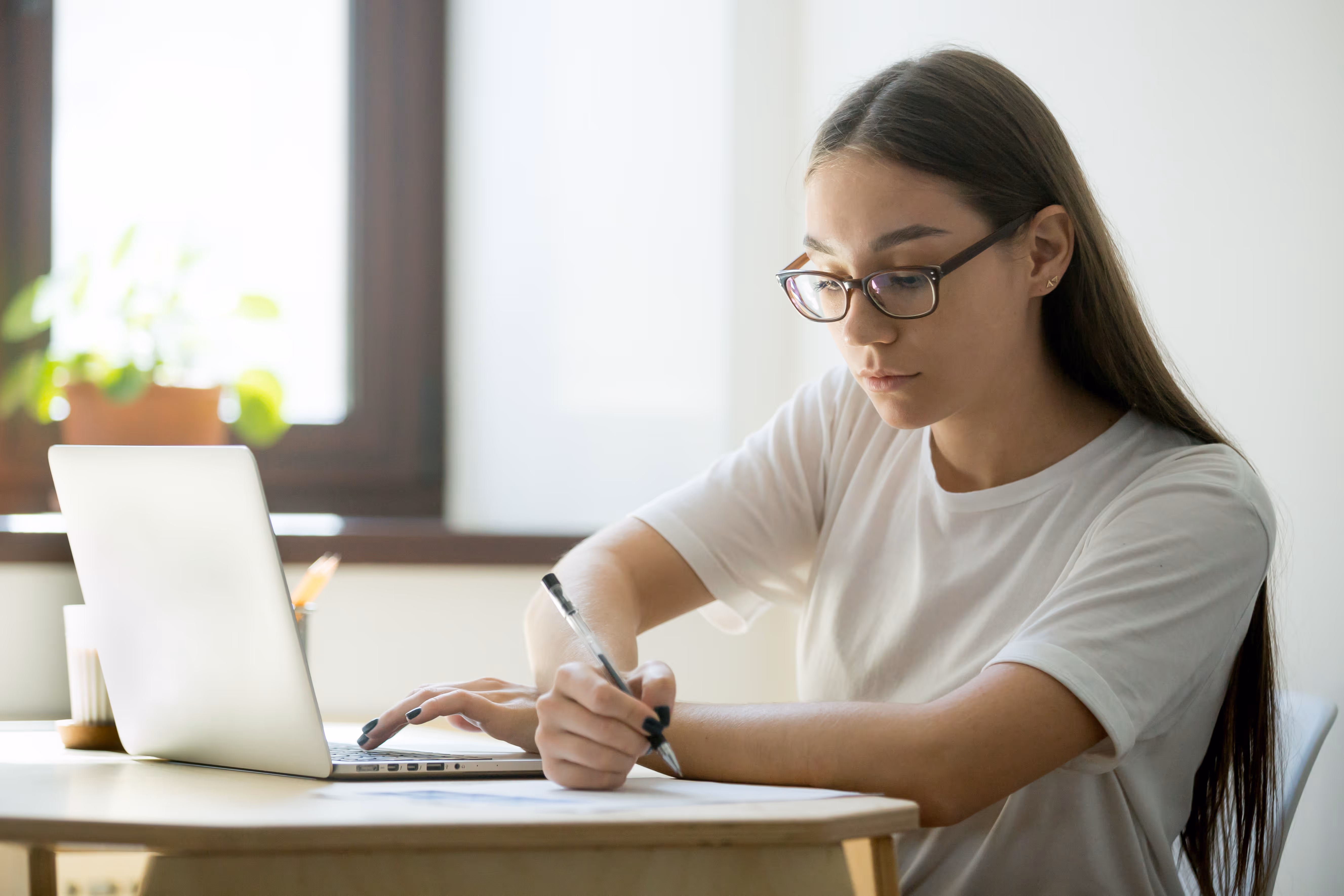 A student preparing for an exam with a laptop and notes